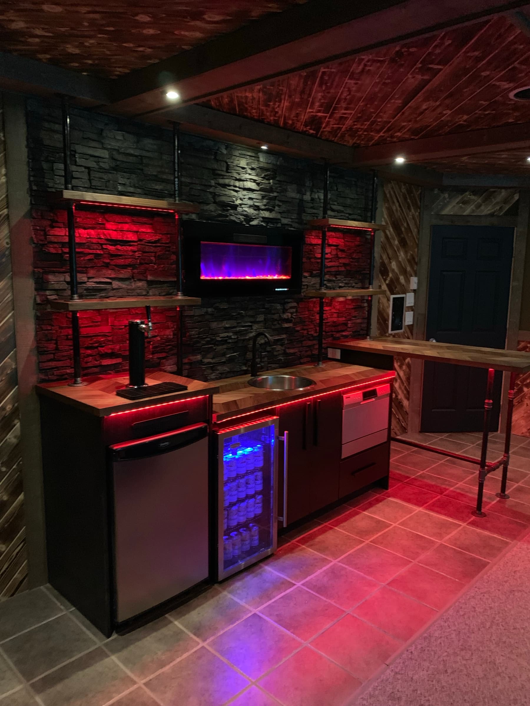 Basement suite living room with stacked-stone fireplace wall and warm lamp light