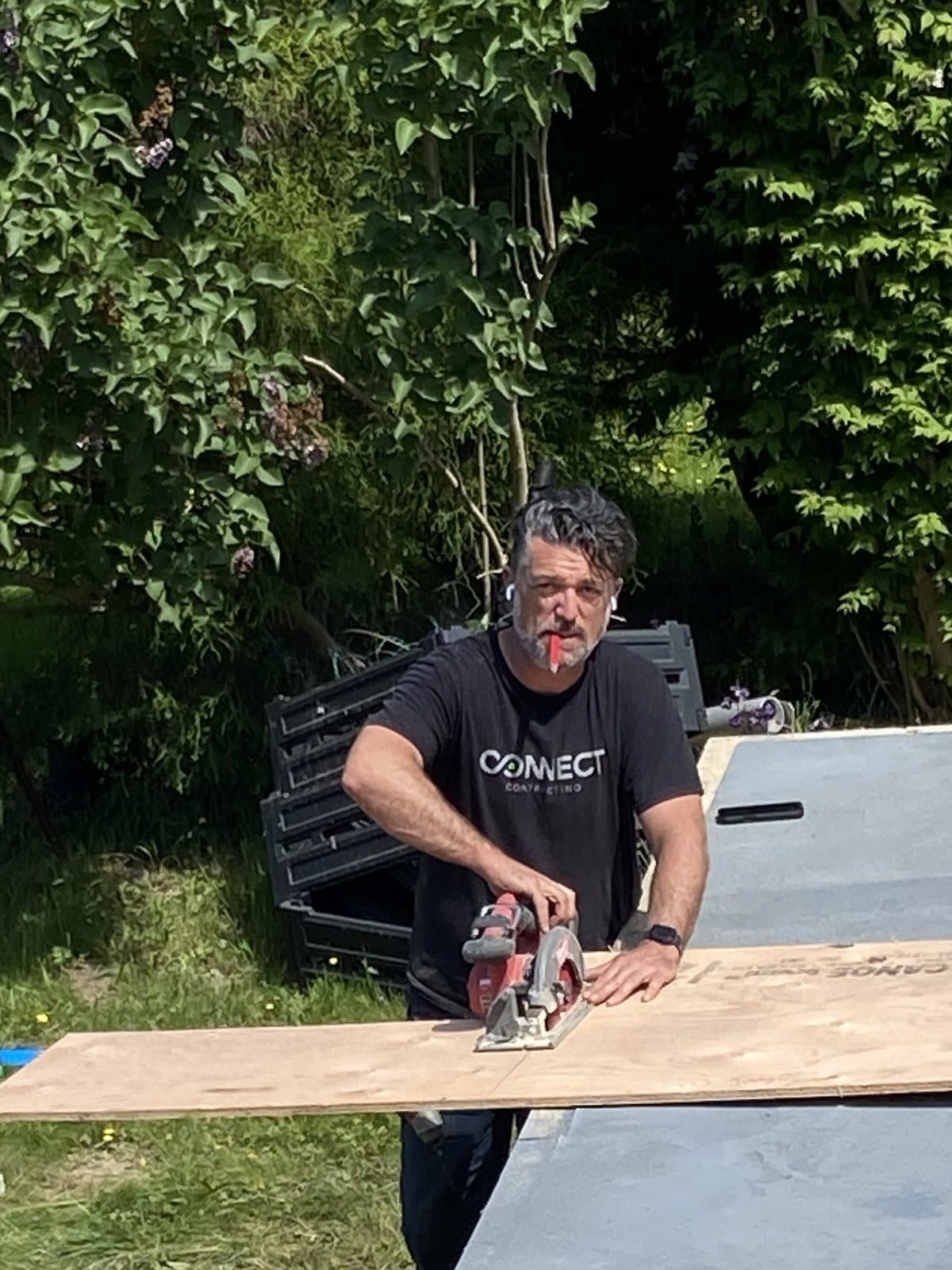 Jonathan Van Dyke cutting plywood with a circular saw on a job site in Abbotsford BC