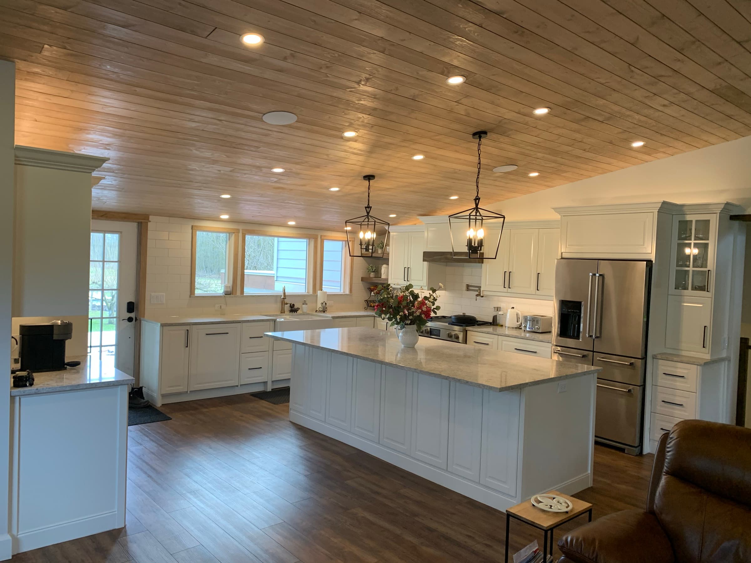 Open-plan kitchen with vaulted shiplap ceiling, white shaker cabinets and quartz island — Abbotsford BC
